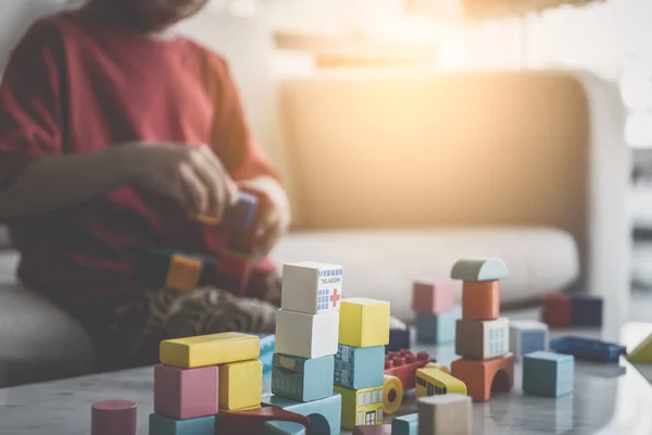 Menino asiático empilhando blocos de brinquedo em uma mesa de sala de estar para criança — Fotografia de Stock