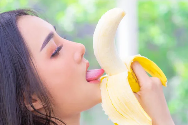 Ασιάτισσα γλείφει κίτρινη μπανάνα για καλό τεστ και αισθησιασμό — Φωτογραφία Αρχείου