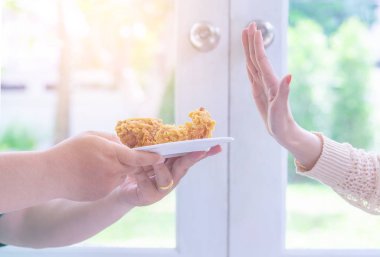 Kadın eli, sağlıklı yemek için kızarmış tavuk yemeyi reddediyor.