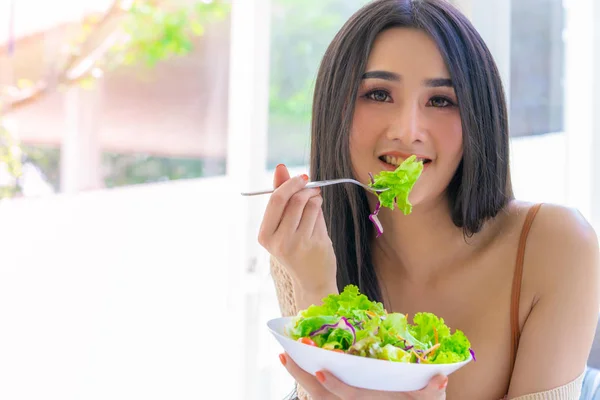 Mulher sorridente feliz está comendo tomate e salada para um corpo saudável — Fotografia de Stock