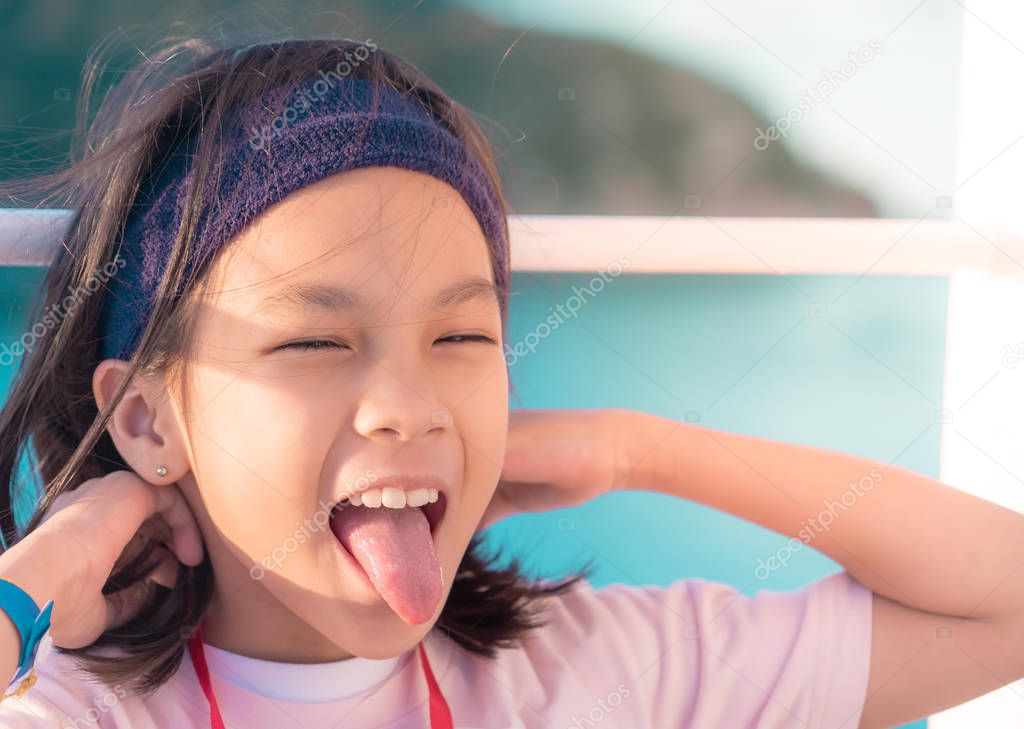 Little asian girl with tongue out for funny expression and amusi