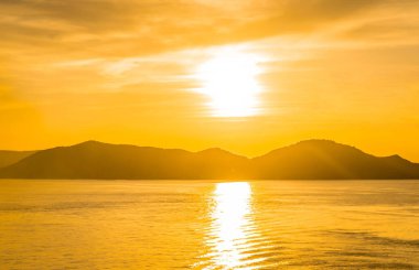 Siluet adasında altın güneş batıyor ve yansıyor 