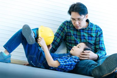 İnşaatçı baba aile bağlantısı için oğlunun yanında oturuyor. 