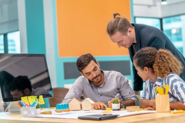 Genç Emlak Müteahhitleri Ekibi ofiste beyin fırtınası yapıyor.