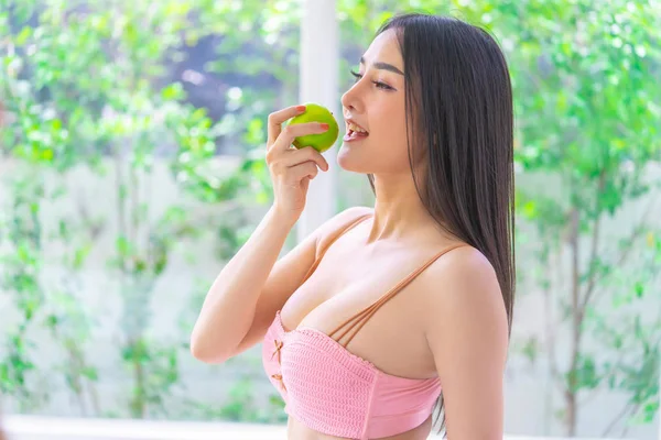 Bella donna sta tenendo mela verde per mangiare frutta sana e — Foto Stock