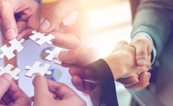 Business team strategy concept with jigsaw and handshaking for b
