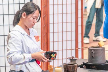 Japon öğrenci geleneksel yeşil çay yapıyor.