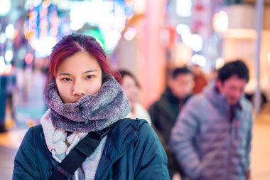 Kızıl saçlı Asyalı kadının portresi Se caddesinde yürüyor.