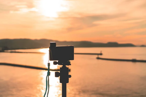 Photographer using Compact Camera to shoot sunset on Japan Islan