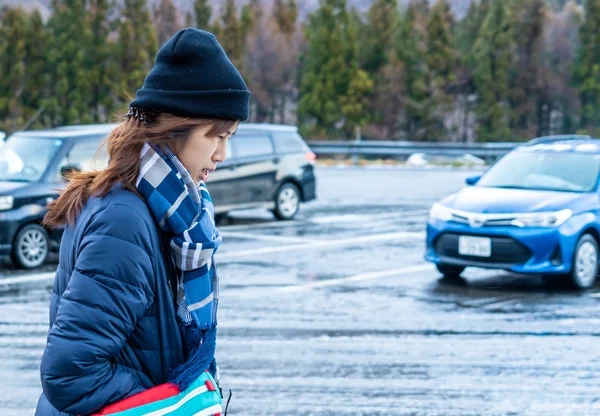 Mujer asiática con ropa de invierno a la moda en una carretera húmeda wi-fi —  Fotos de Stock