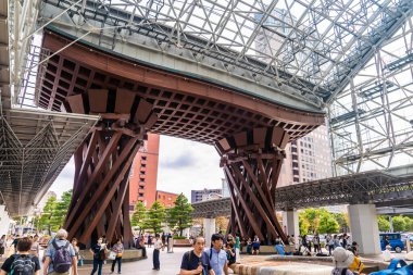 Kanazawa, Japonya - 29 Eylül 2019: Yolcular Kanazawa istasyonunda ahşap giriş kapısından geçiyorlar. 