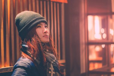 Ginzan Onsen 'de gece kar yağarken gezen kadın turistin portresi