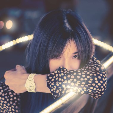 Açık Hava Festivali 'nde parlak Bokeh ışığında oturan bir kadının portresi.