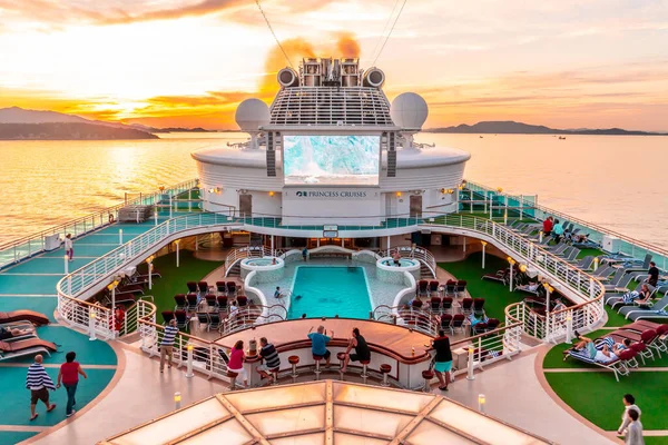 Takamatsu, Japan - 25 Sep 2019 : Tourist are relaxing on the top deck of Diamond Princess cruise ship with large LED TV and swimming pool.