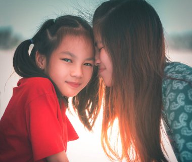 Asyalı anne ve Duaghter sevgi, sevgi ve aile birlikteliği konsepti için öpüşüp sarılıyorlar.