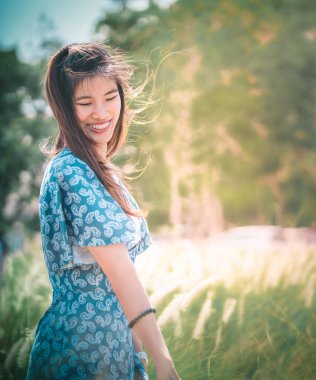 Mutlu Asyalı Çinli güzel kadın özgürlük için doğa ile dolu bir alanda yürüyor mutlu yaşam tarzı konsepti.