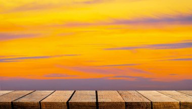 Reklam arkaplanı ve turuncu gün batımı gökyüzü arkaplanı için fotokopi alanı olan boş tahta tahta raf masası tezgahı.