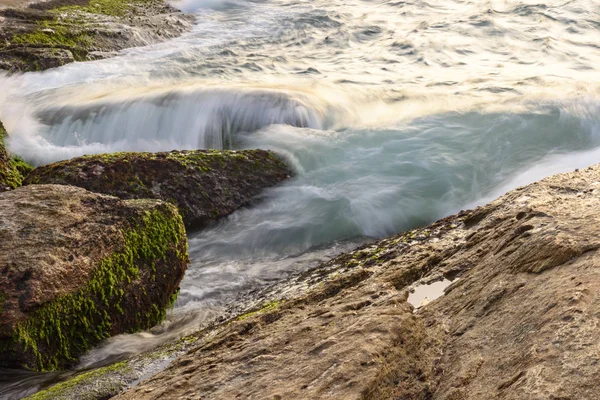 Капающая между скалами вода — стоковое фото