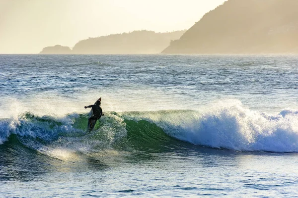 Surfer in de Golf bij zonsondergang — Stockfoto