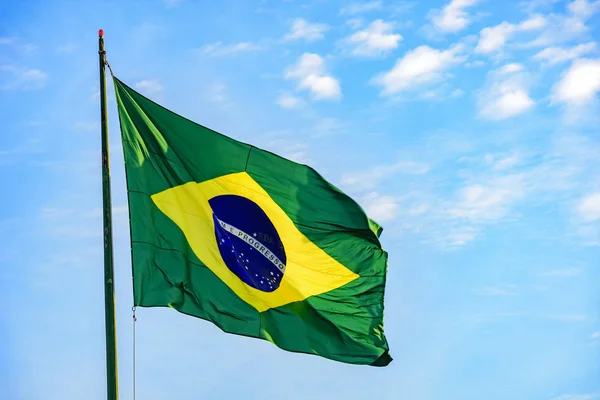 Brazilská vlajka s modrou oblohou — Stock fotografie