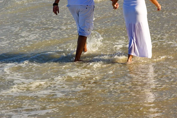 Пара прогулок по пляжному песку — стоковое фото