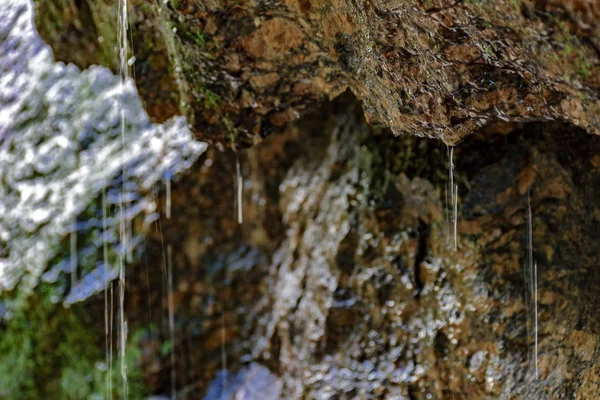 Regenwater druipend op de rotsen — Stockfoto