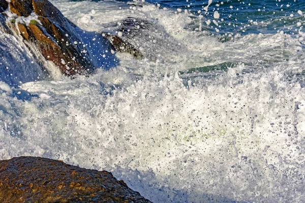 Sea water spray over the stones — Stock Photo, Image
