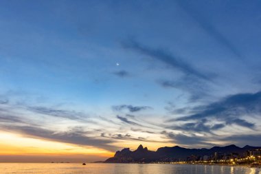 Ipanema Plajı Rio de Janeiro ve şehir ışıkları günbatımında yaz
