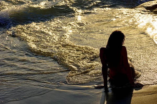 Девушка сидит на песке — стоковое фото