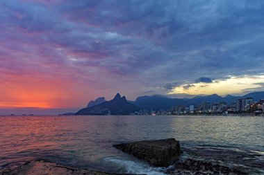 Rio de Janeiro, Plajı yaz günbatımı iki kardeş hill ve Vidigal gecekondu ile bulutlu gökyüzü ile göster