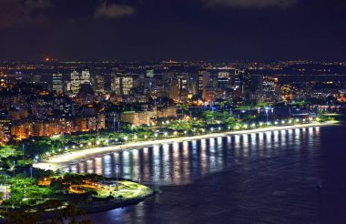 Gece manzarasını Rio de Janeiro şehir merkezinde şehir ışıkları, binalar, plaj ve sokakları ile bir yaz gecesi