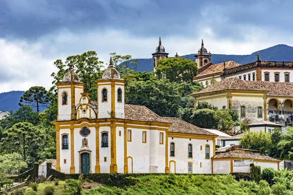 Evler ve sokaklar Minas Gerais Hills Ouro Preto'daki şehirde ve arka planda bulutlar arasında antik tarihi kiliseler