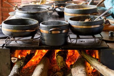Geleneksel odun sobası bir çiftlik mutfağında tipik Brezilya yemeği hazırlıyor.