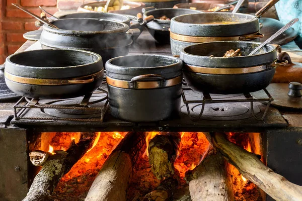 dos grandes ollas de hierro cocinando sobre un fuego de leña para una  comida en el campo Stock Photo