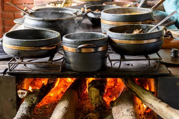 Geleneksel odun sobası bir çiftlik mutfağında tipik Brezilya yemeği hazırlıyor.