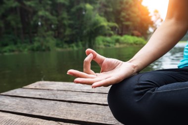 Eller yukarıda kapatın. Kadın yoda açık. Doğa arka plan seçin odak Yoga egzersiz kadın