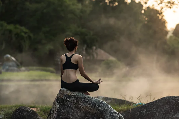 Fata tânără care face exerciții de fitness yoga în aer liber într-un peisaj frumos. Dimineața răsăritul — Fotografie, imagine de stoc