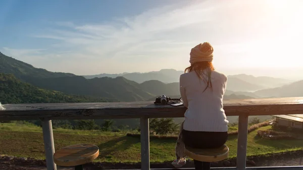 彼女の朝のコーヒーを楽しんで太陽の光で屋外に座って太陽の下でコーヒーを飲んでいる女性。笑顔幸せな混血女性アジア中国 — ストック写真