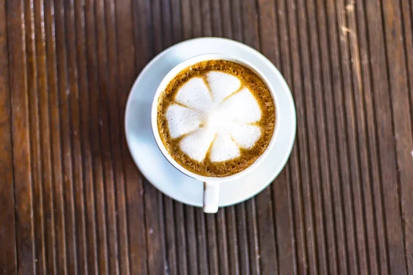Cappuccino coffee cup på brunt trä bordsbakgrund — Stockfoto