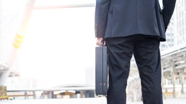 Saat çalışmak için bir iş briefcase.businessman evrak çantası tutarak ve gidiş tutarak iş adamı