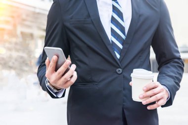 Genç işadamı takım kapatmak ve kravat smartphone kullanarak ve kahve içme açık duruyor. İş stratejisi. Online Pazarlama, eğitim.