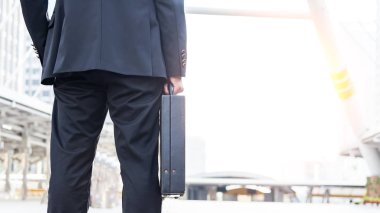 Saat çalışmak için bir iş briefcase.businessman evrak çantası tutarak ve gidiş tutarak iş adamı