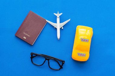 Çalışma masası ve düz yatıyordu tasarım uçak ve gözlük ile mavi arka plan üzerinde planlama. Seyahat kavramı.