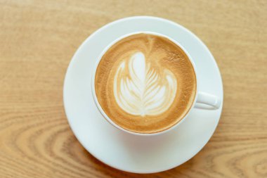 Cappuccino kahve Kupası kahverengi ahşap masa arka plan üzerinde