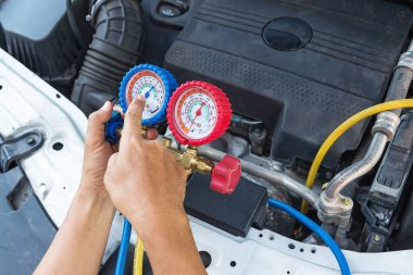 Otomatik mekanik dijital multimetre kullanarak bir araba içinde sigorta denetlemek için gerilim seviyesi akü kontrol.