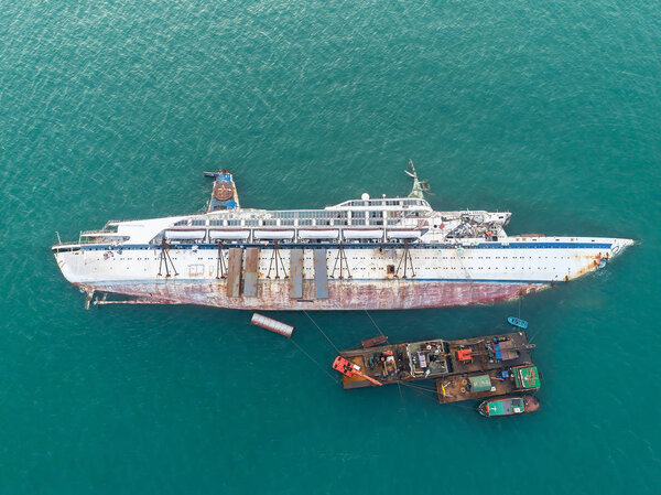 Boat crashes in the sea, cruise ship, accident, Ship wreck.disaster of the passenger vessel capsize and sink into the sea ocean at sunset in aerial view
 