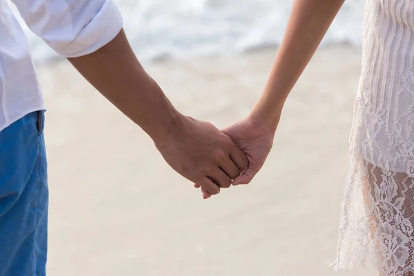 couple in love hand in hand on beach in summer holiday