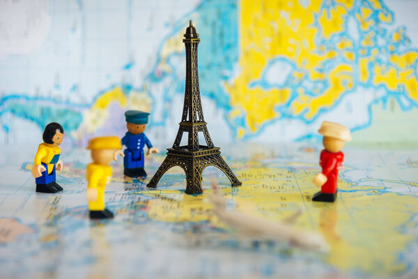 Миниатюрные люди с путешествующими концепциями. Группа туристов ходит по паспорту с марками. Концепция путешествия или знакомства с миром, бюджетная трава
