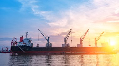 Vinçler ve endüstriyel kargo için arka plan bağlantı noktası için alacakaranlık gemi..