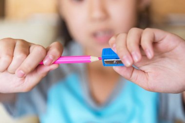 küçük kız bir kalem keskinleştirmek.